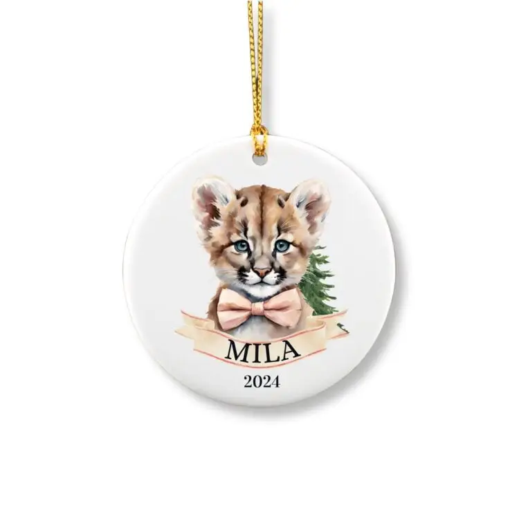 Personalized Christmas ornament showcasing a cute female mountain lion wearing a pink bow tie in front of a pine tree