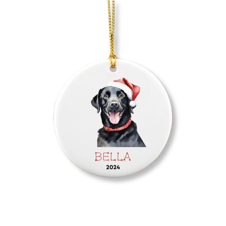 Personalized ornament showcasing a cute black labrador with a Christmas red hat in front of a pine tree